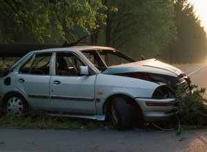 Зруйнована машина заплуталася в дереві на узбіччі сільської дороги на світанку